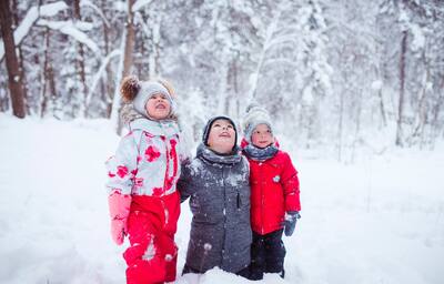 Three children bundled up amid snow drifts