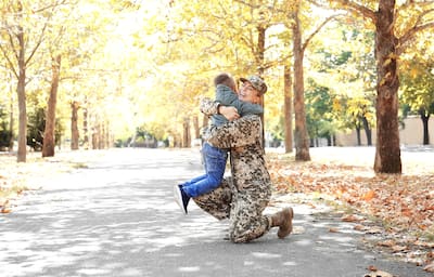 Military mother hugging child