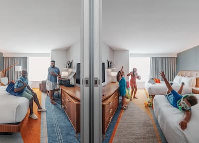 Guests hanging out in adjacent hotel rooms, connected by open doorway