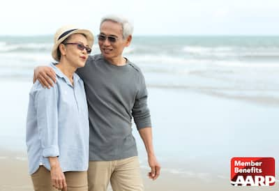 Older couple walking on beach together