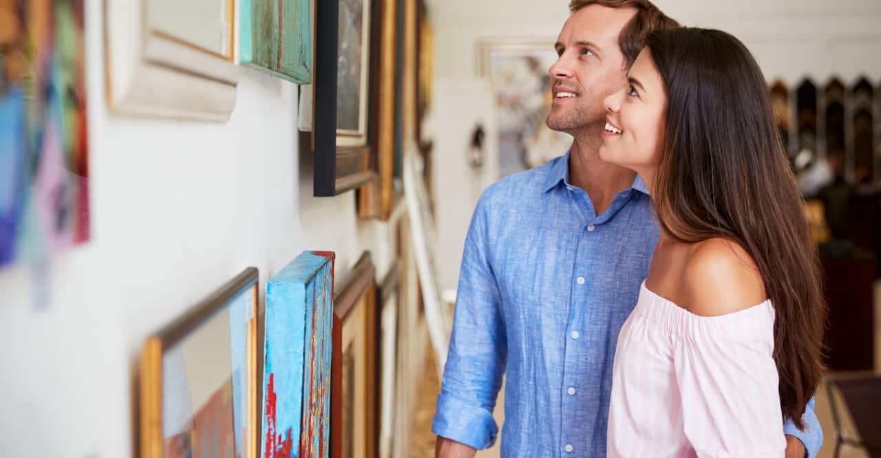 couple looking at painting in art gallery