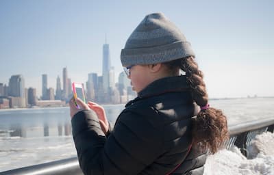 Young girl on phone looking at New York City