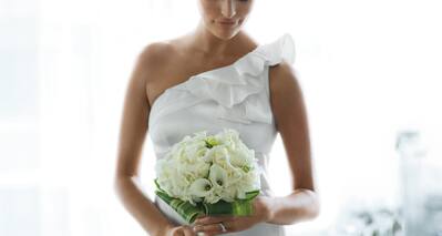 Brunette Bride With Closed Eyes Holding Bouquet of White Flowers 