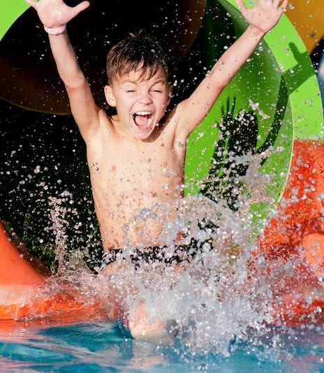 Boy has into pool after going down water slide during summer