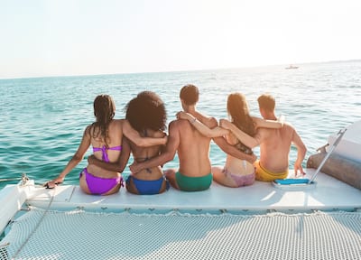 Young friends chilling in catamaran boat 