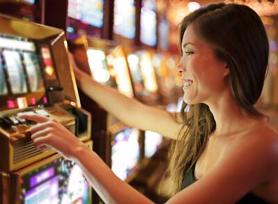 Smiling woman at slot machines in an Atlantic City casino. 