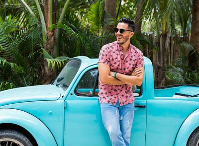 Latin man traveling in bright blue car in Tulum, Mexico.