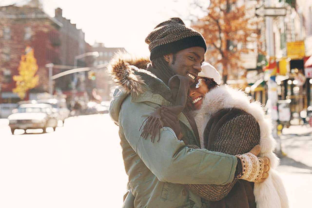 Couple Wearing Winter Coats Hugging In the Street