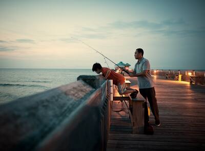 Man and Boy Fishing off Pier