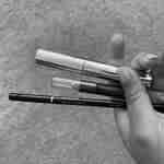 Tangan memegang berbagai produk tata rias