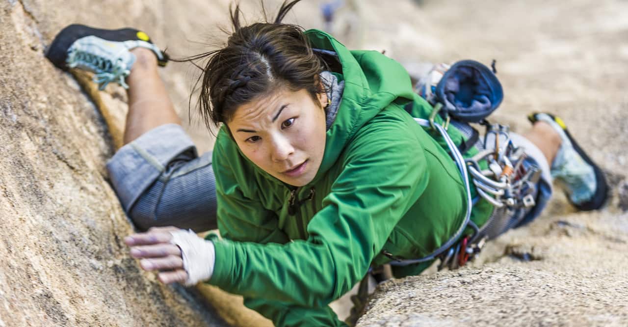 Female climber struggles for her next grip on a challenging ascent in Joshua Tree National Park.