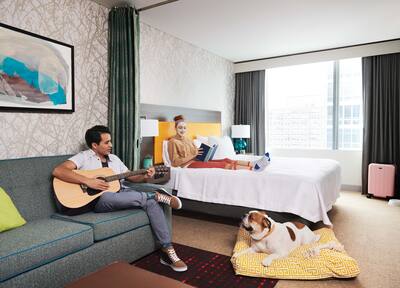 A couple with their pet dog in a two-room suite