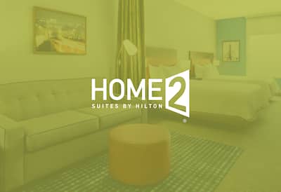 A suite with the Home2 Suites by Hilton logo layered over the top of the image