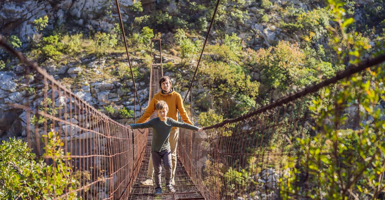 Father and son walking on a suspension bridge