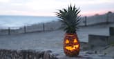 Pineapple jack o' lantern on the beach for Halloween.