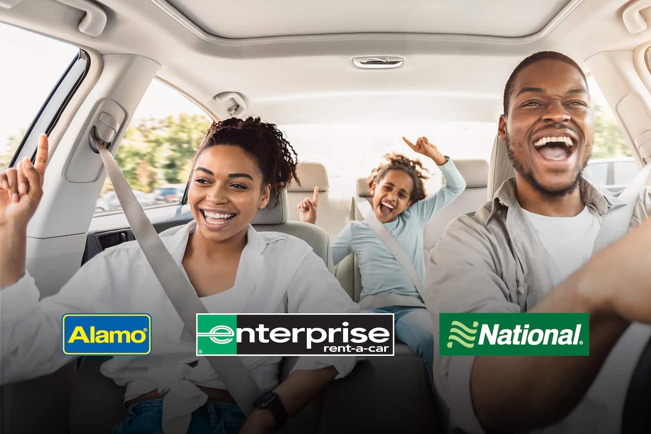 Family of three having fun in a rental car