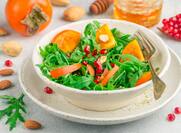 Delicious salad of fresh arugula, persimmon, pomegranate and almonds with a dressing of olive oil and honey.