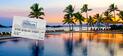 An image of a sunset with palm trees and a pool in the foreground. A Hilton Gift Card is displayed within the image.
