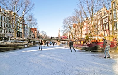 Ice skating on the canals in Amsterdam the Netherlands in winter.