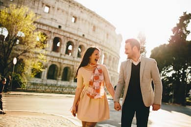 Young couple holding hands in front of the Colosseum, Rome, Italy
