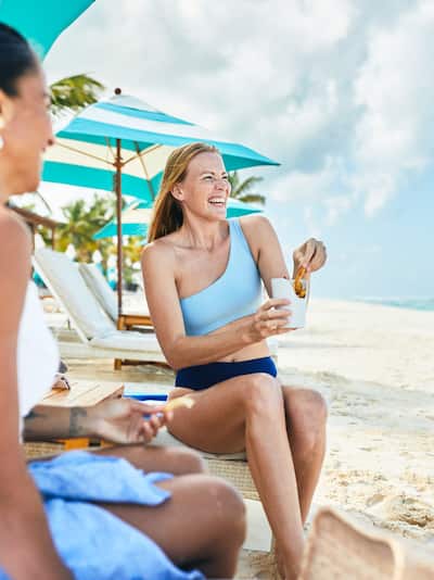 Women relaxing on beach with snacks