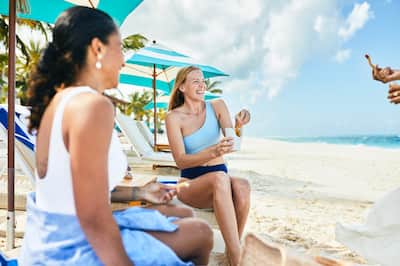 Women relaxing on beach with snacks