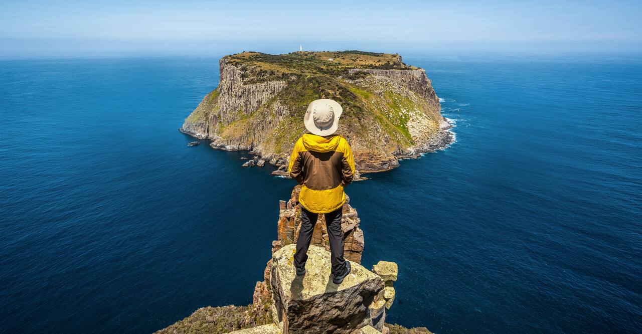 Hiker overlooking Tasman Island close to south coast of Tasmania, Australia near Port Arthur. 