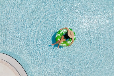 Woman in a pool floating on a green tube