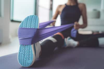 Woman uses resistance band while stretching