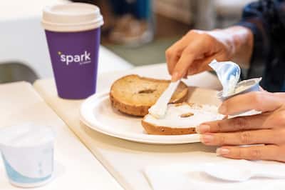 Closeup of person spreading cream cheese onto a bagel