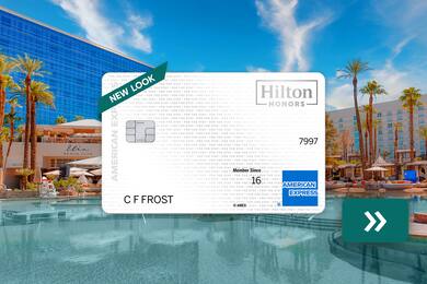 The Hilton Honors American Express Card with a pool in the background
