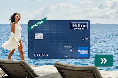 The Hilton Honors American Express Surpass® Card with a woman walking along the beach in the background