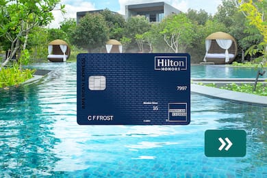 The Hilton Honors American Express Aspire Card with a pool in the background