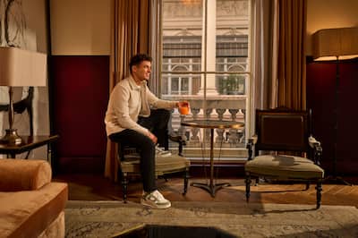 Lando Norris sitzt auf dem Sessel und hält Orangendrink