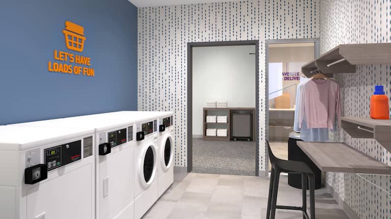 Laundry room with machines, table and chair