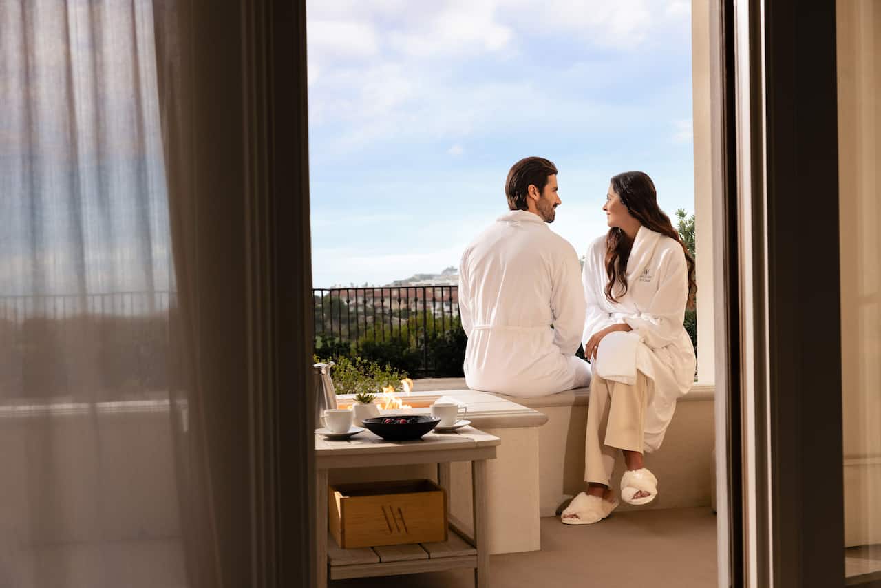 Couple sitting on balcony outside of hotel room