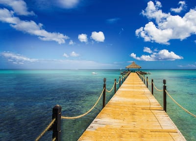 Long wooden pier over water with cloudy sky