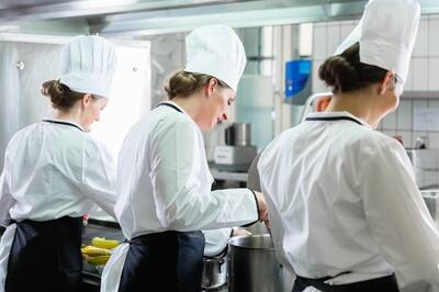 Group of team members cooking in industrial kitchen