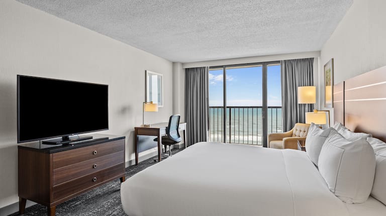Large Bed in a Guest Room with HDTV Desk and Ocean View from Balcony