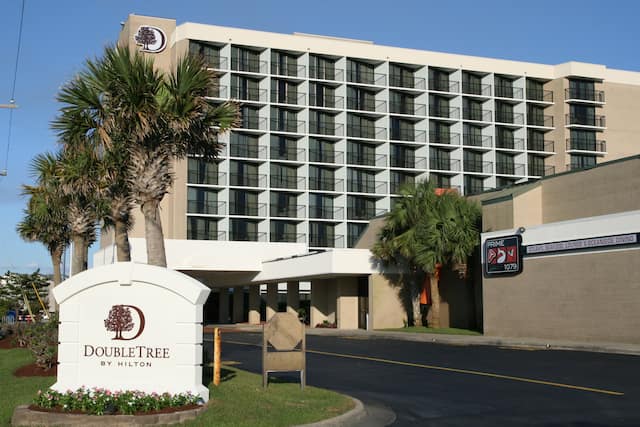 Daytime View of Hotel Signage, Exterior, and Landscaping