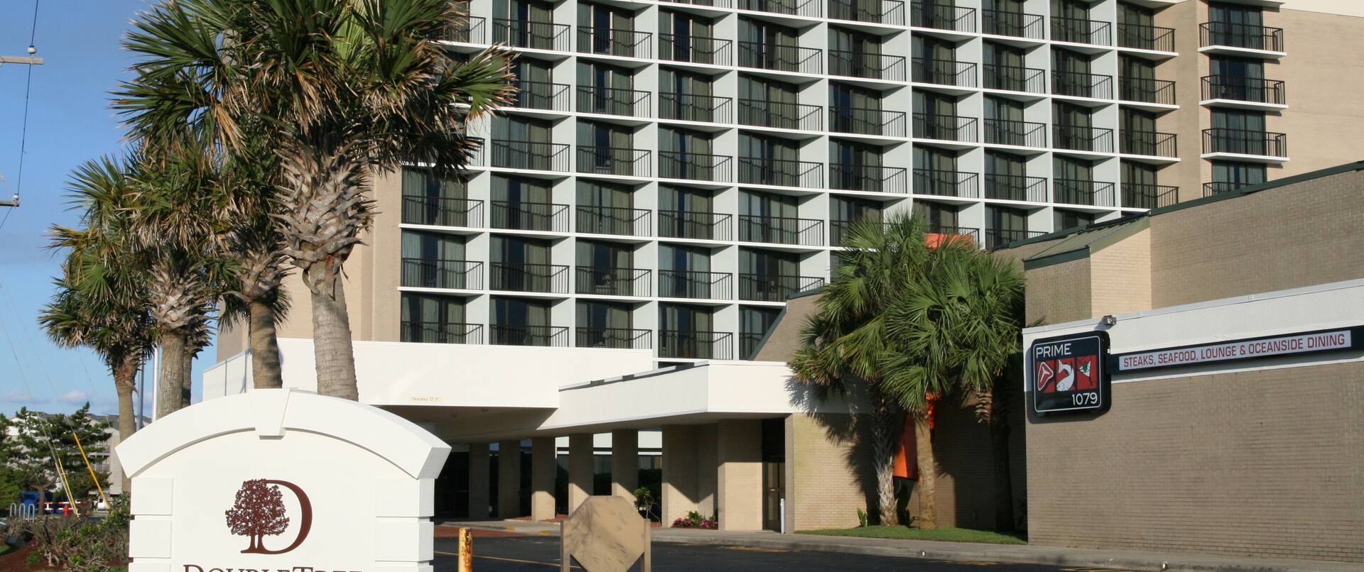 Daytime View of Hotel Signage, Exterior, and Landscaping