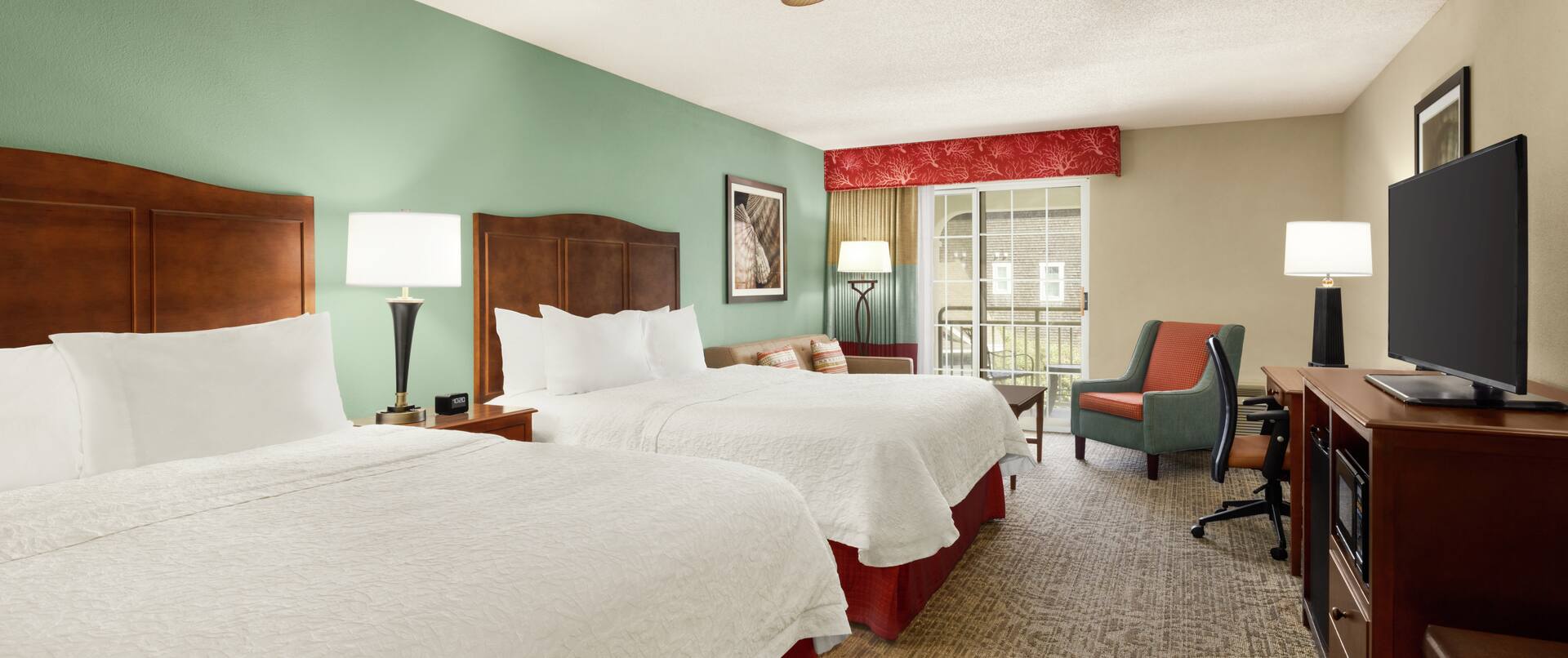 Spacious accessible guestroom featuring two comfortable queen beds, sofa, and private balcony.