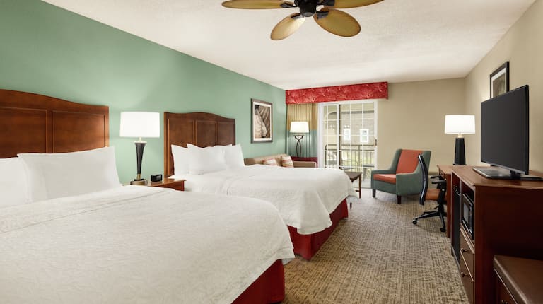Spacious accessible guestroom featuring two comfortable queen beds, sofa, and private balcony.