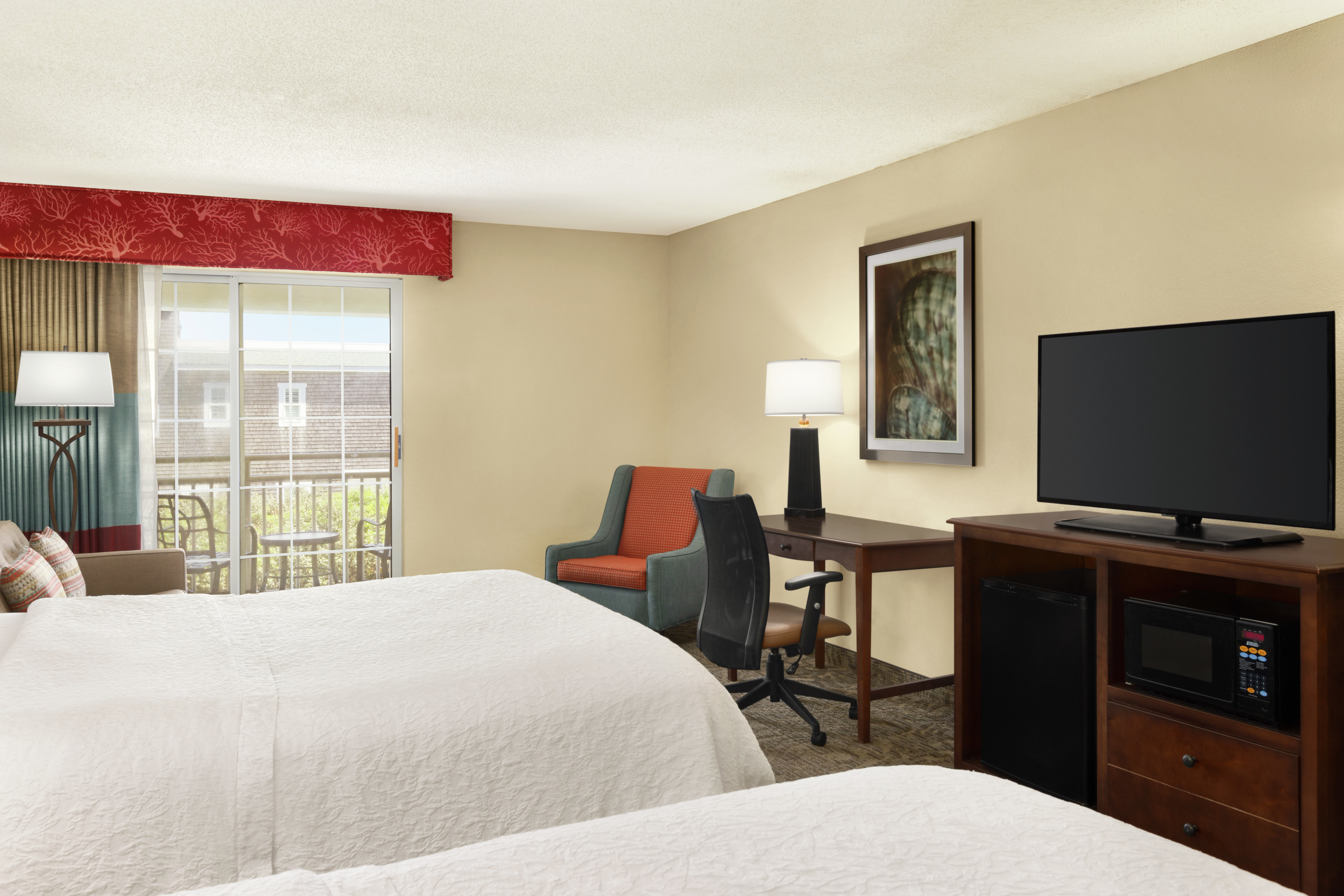 Spacious accessible guestroom featuring work desk, TV, sofa, and private balcony.