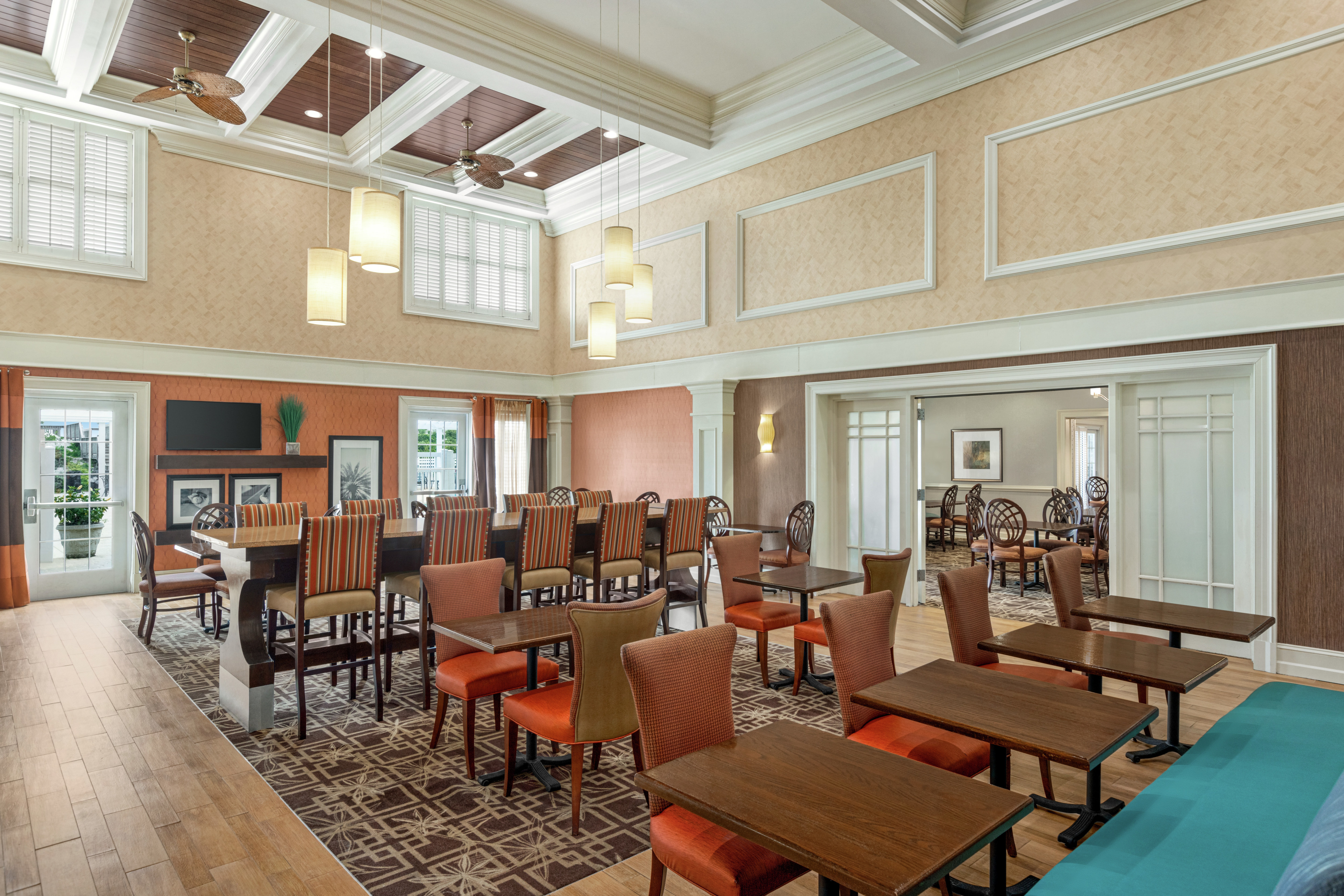 Spacious breakfast seating area featuring ample seating, high ceilings, and TV.
