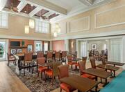Spacious breakfast seating area featuring ample seating, high ceilings, and TV.