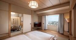 Bedroom in Tatami Styled Family Suite With Bed, TV, Window With Open Drapes to City View, and Open Doorway to Dining Area