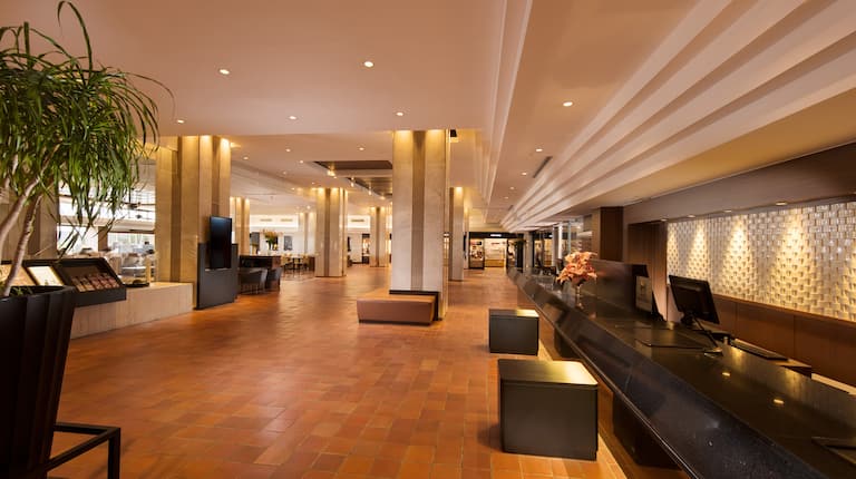 フロントデスクの座席とコンピューター、窓を備えたロビーのラウンジエリア