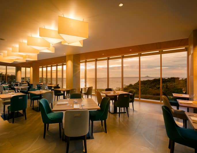 Grill Dining Area with Large Windows at Sunset