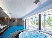 Indoor Pool Area with Whirlpool and Lounge Chairs